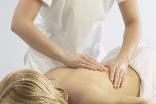 a woman getting a massage on her pregnant stomach at Ensana Svoboda in Mariánské Lázně