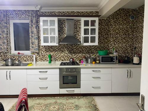 a kitchen with white cabinets and a stove at De La Terrasse IZNIK in İznik