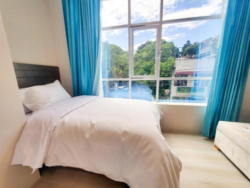 a bedroom with a bed and a large window at Xperience Hotel Ec in Baños