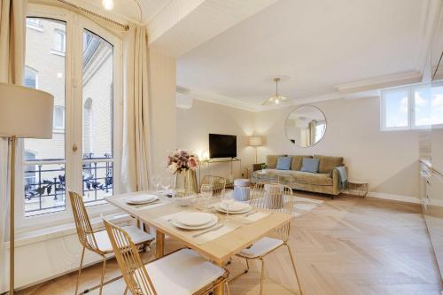 un salon avec une table, des chaises et un canapé dans l'établissement Charming apartment - 1BR-4P - Montmartre, à Paris
