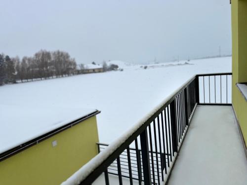 a balcony with snow on the roof of a building at Apartment Golden Prague 78 in Vestec
