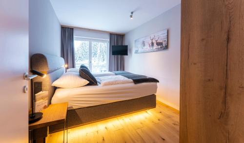 a hotel room with a bed and a window at Hotel Residenz Hochalm - Joker Card Partner in Saalbach Hinterglemm