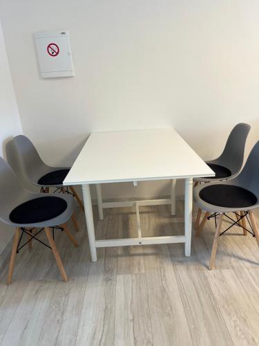 a white table with four chairs around it at Apartment Golden Prague 78 in Vestec