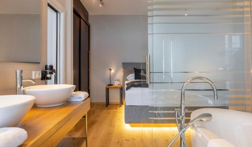 ein Badezimmer mit zwei Waschbecken und einem großen Spiegel in der Unterkunft Hotel Residenz Hochalm in Saalbach-Hinterglemm