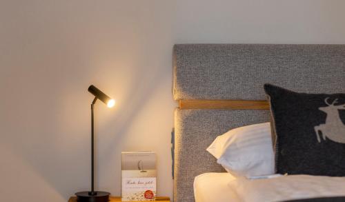 a bedroom with a bed with a lamp and a pillow at Hotel Residenz Hochalm - Joker Card Partner in Saalbach Hinterglemm