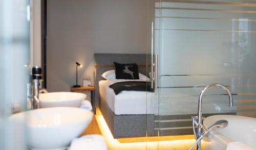 a bathroom with a bed and two sinks and a tub at Hotel Residenz Hochalm - Joker Card Partner in Saalbach Hinterglemm
