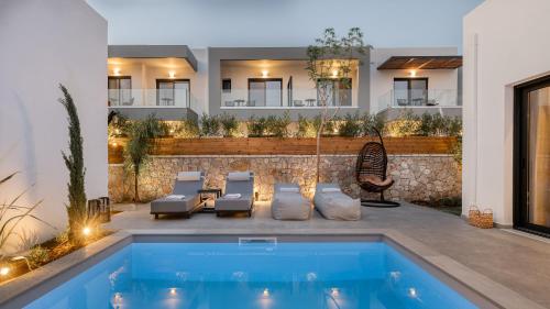 a swimming pool with lounge chairs and a house at Sezian Boutique Homes and Villas in Preveza