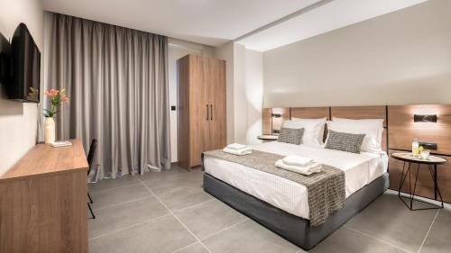 a hotel room with a bed and a television at Sezian Boutique Homes and Villas in Preveza