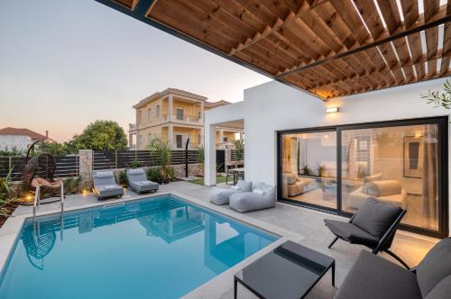 a swimming pool with chairs and a house at Sezian Boutique Homes and Villas in Preveza