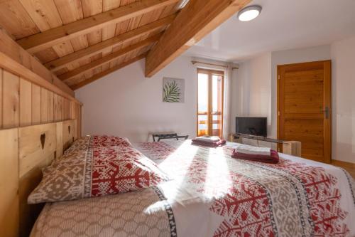 a bedroom with a bed with a red and white bedspread at La Maison de Catherine in Puy-Saint-Pierre