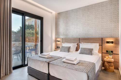 a bedroom with a large bed and a balcony at Sezian Boutique Homes and Villas in Preveza