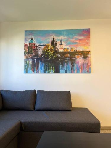 a painting hanging on a wall above a couch at Apartment Golden Prague 78 in Vestec