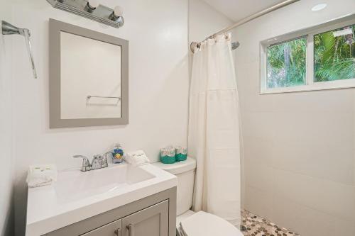 uma casa de banho com um lavatório, um WC e um espelho. em Tropical Retreat ** 2 BR ** Singer Island em West Palm Beach