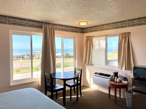 um quarto com uma mesa e duas cadeiras e uma cama em Coast Riders Inn em San Simeon