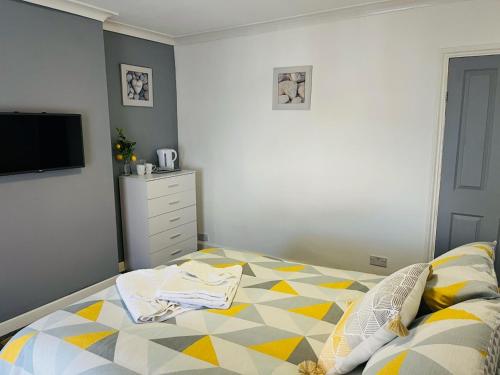 a bedroom with a bed and a dresser and tv at MayDisc Long Stay Contractors Portsmouth Stays in Portsmouth