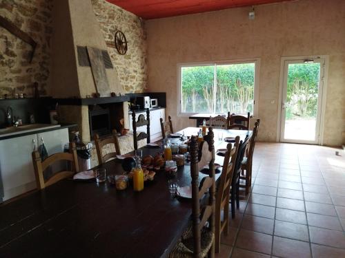 una sala da pranzo con un lungo tavolo e sedie di Aur Blan - Chambres Le Somail a Le Somail