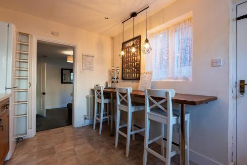 a kitchen with a wooden table and stools at Springfield Place - 3 Bed Cent Reading - Long term savings - Free Parking in Reading
