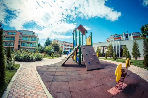 a playground with a slide in a park at Sunny Fort Apartments in Sunny Beach