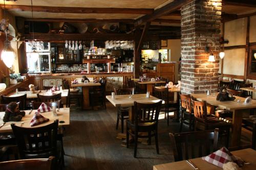 ein Restaurant mit Tischen und Stühlen und einer Ziegelwand in der Unterkunft Landgasthof zur krummen Linde in Stolpe