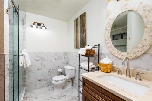a bathroom with a sink and a toilet and a mirror at Serenity Summit Cabin in Big Bear Lake