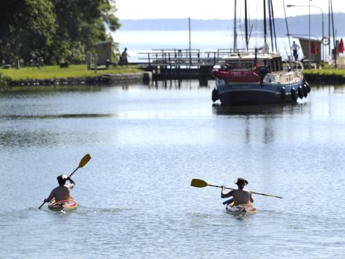 two people are paddling in the water with a boat at Bergs Slussar Vandrarhem & Stugor in Vreta Kloster
