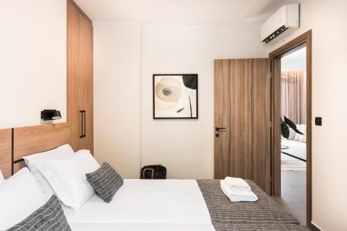 a bedroom with a white bed and a mirror at Sezian Boutique Homes and Villas in Preveza