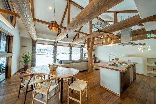 uma cozinha e sala de estar com mesa e cadeiras em 　白馬　コテージ　チェスナッツ em Hakuba