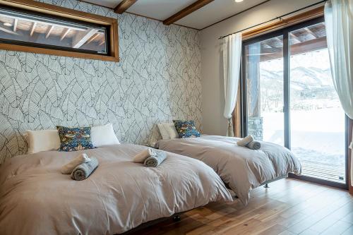 白馬村にある　白馬　コテージ　チェスナッツの窓付きの客室で、ベッド2台が備わります。