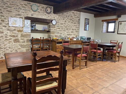 a dining room with tables and chairs and a stone wall at Casa Sara in Cantavieja