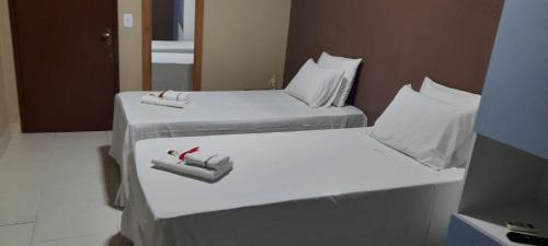 twee bedden in een hotelkamer met handdoeken erop bij Pousada Tartaruga in Cumbuco