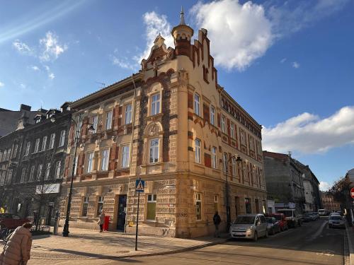 um grande edifício de tijolos com uma torre de relógio numa rua em Old Market Residence na Cracóvia