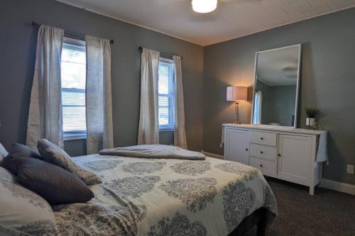 a bedroom with a bed with a mirror and a dresser at Freshly Renovated 3BR House near Genesis West SAU in Davenport