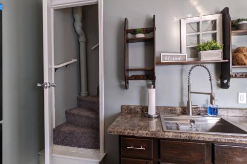uma cozinha com um lavatório e uma escada em Freshly Renovated 3BR House near Genesis West SAU em Davenport