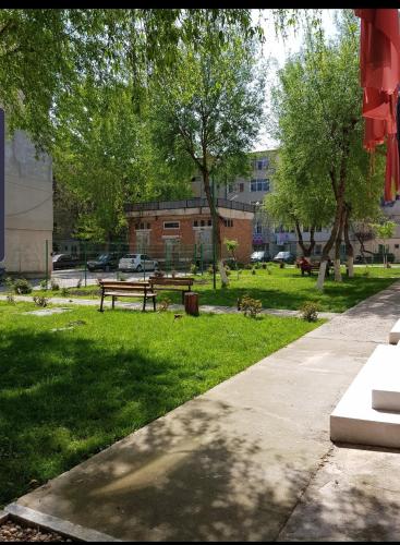 a park with a bench and trees and a building at Garsoniere Aby in Turnu Măgurele