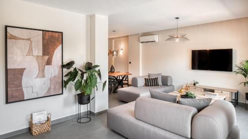 a living room with a couch and a tv at Sezian Boutique Homes and Villas in Preveza