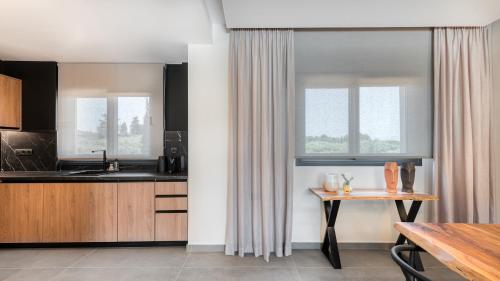a kitchen with wooden cabinets and a table and window at Sezian Boutique Homes and Villas in Preveza