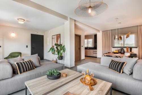 a living room with two couches and a table at Sezian Boutique Homes and Villas in Preveza