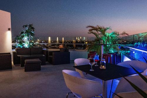 a rooftop patio with a table and chairs and a pool at Mesón de la Luna Hotel & Spa in Mérida
