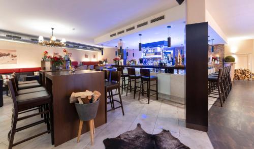 a bar in a restaurant with chairs and a counter at Hotel Residenz Hochalm - Joker Card Partner in Saalbach Hinterglemm