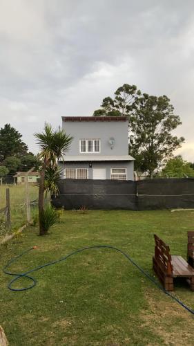 una casa con un jardín con una manguera verde en Casita Santa Ana Miramar Buenos Aires en Miramar