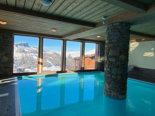 une piscine avec vue sur les montagnes dans l'établissement Plagne Villages, Charmante Résidence de Tourisme 4 Etoiles, à Plagne Villages