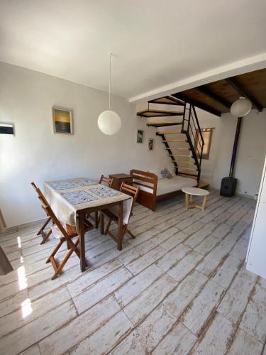 ein Esszimmer mit einem Tisch, Stühlen und einer Treppe in der Unterkunft Casita Santa Ana Miramar Buenos Aires in Miramar