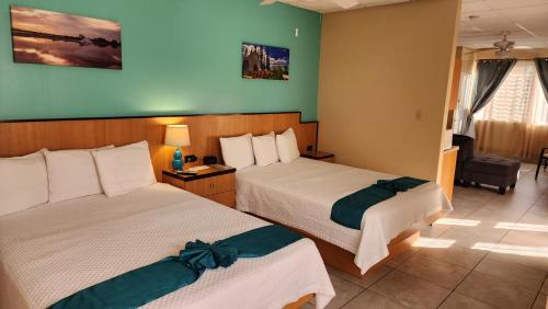 a hotel room with two beds and a chair at Combate Beach Resort in Cabo Rojo