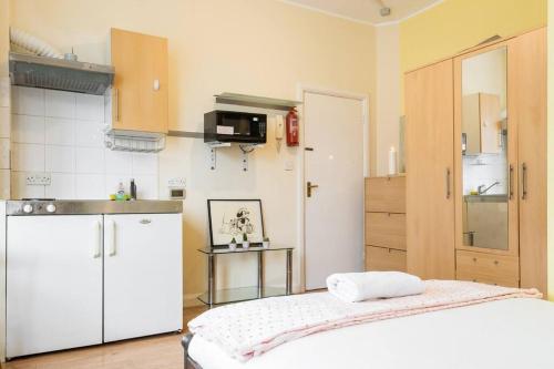 a small kitchen with a white refrigerator and a counter at Studio Appartment 2, sleeps up to two people. in The Hyde
