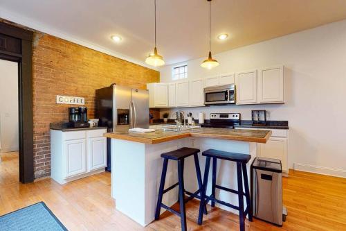 a kitchen with white cabinets and a counter with stools at Private Home-Backyard-Parking Near Nulu Downtown in Louisville