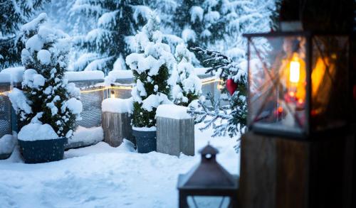 a snow covered yard with trees and a light at Hotel Residenz Hochalm - Joker Card Partner in Saalbach Hinterglemm