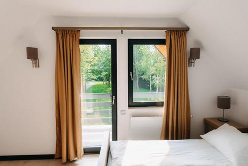 a bedroom with a bed and a large window at Good House in Vlăhiţa