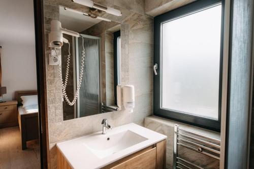 a bathroom with a sink and a mirror at Good House in Vlăhiţa