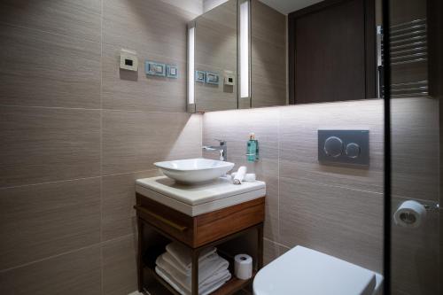 y baño con lavabo y espejo. en Paloma Apartment - Portonovi Resort, en Herceg-Novi