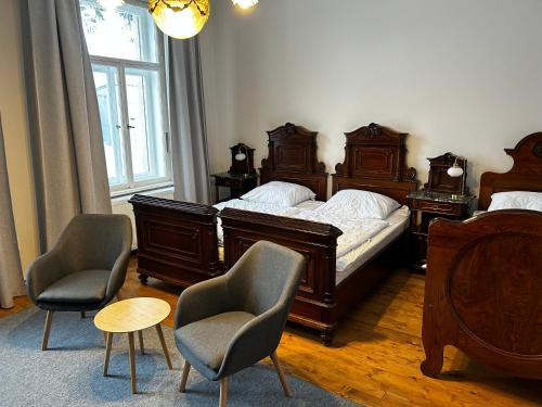 a bedroom with two beds and two chairs at Vila Bohemia Saxon Switzerland in Šluknov